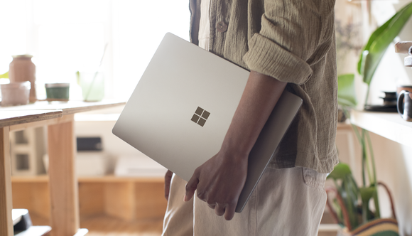 Man holding a Surface laptop.