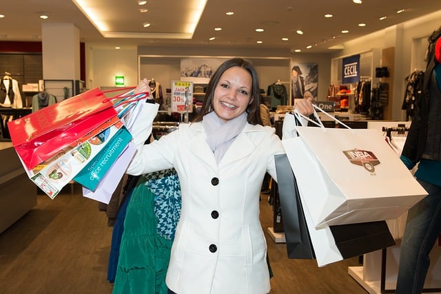 A woman shopper holding a number of shopping bags. 