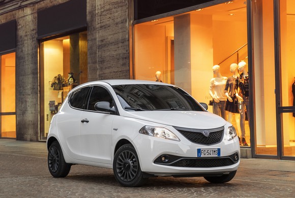 A white Lancia Ypsilon hatchback on a city street. 