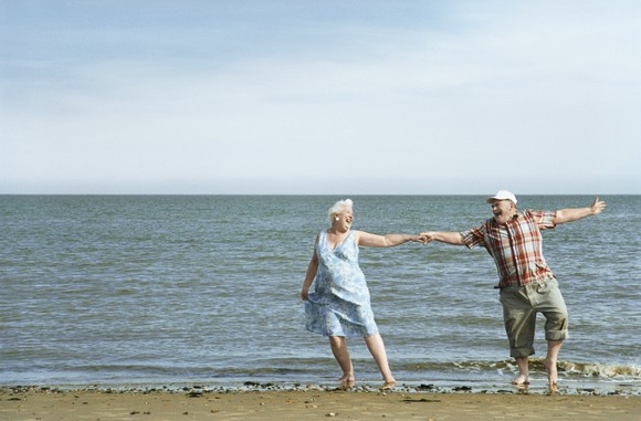 A senior couple dancing on the beach.