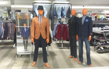 The inside of a Macy's store with men's attire on display.