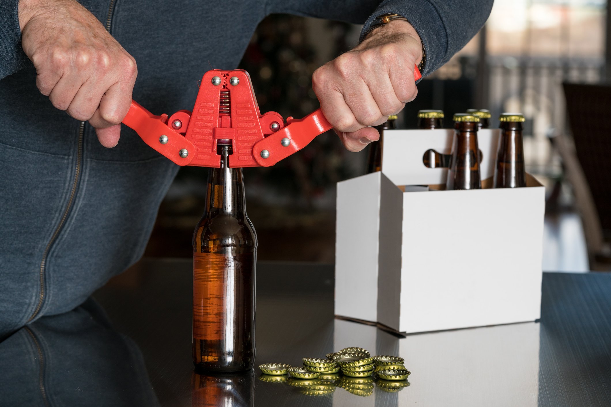 A home brewer caps beer bottles