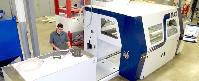 A man working next to ExOne's large S-Max 3D printer.