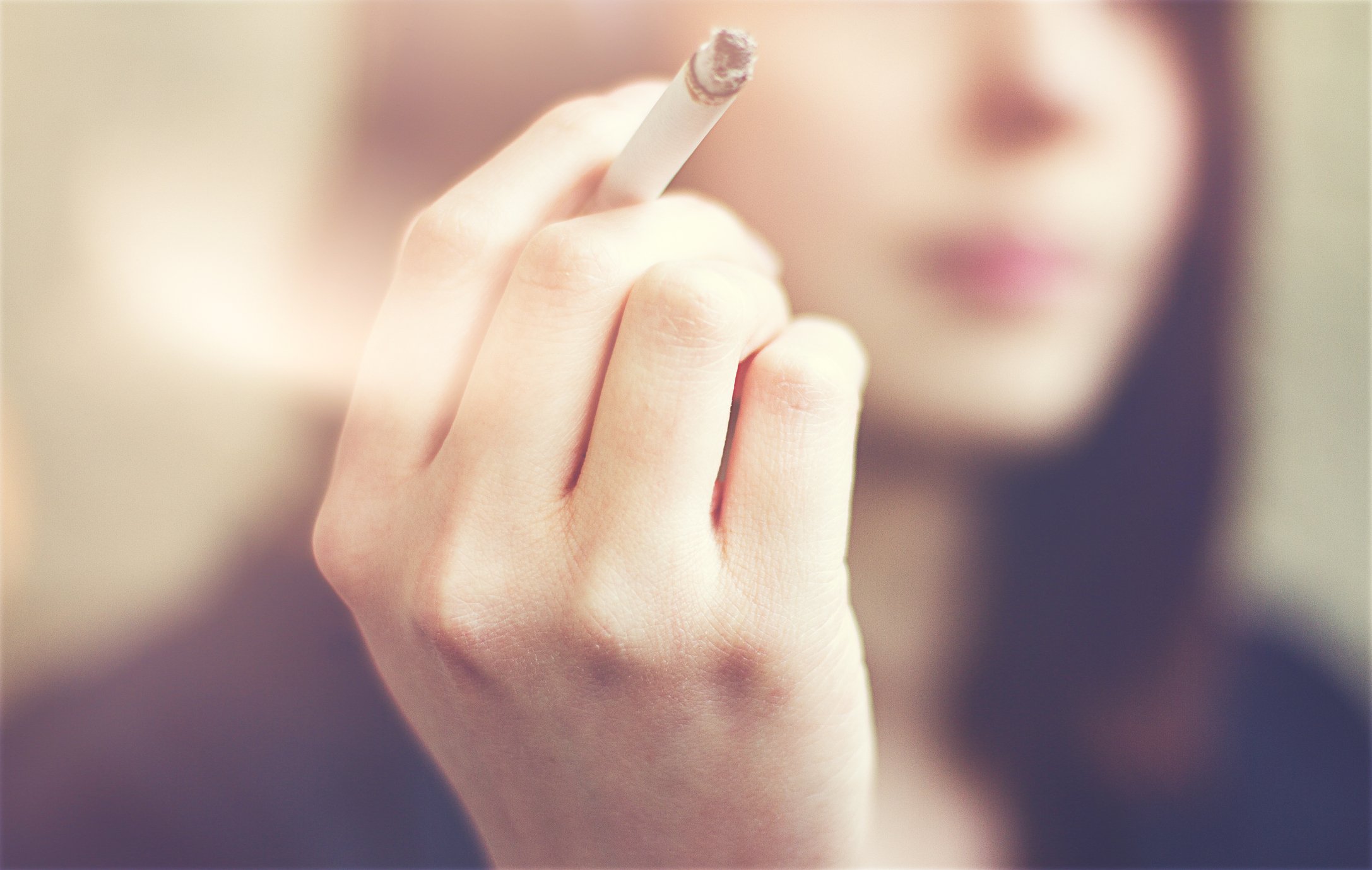 A woman holding a cigarette.