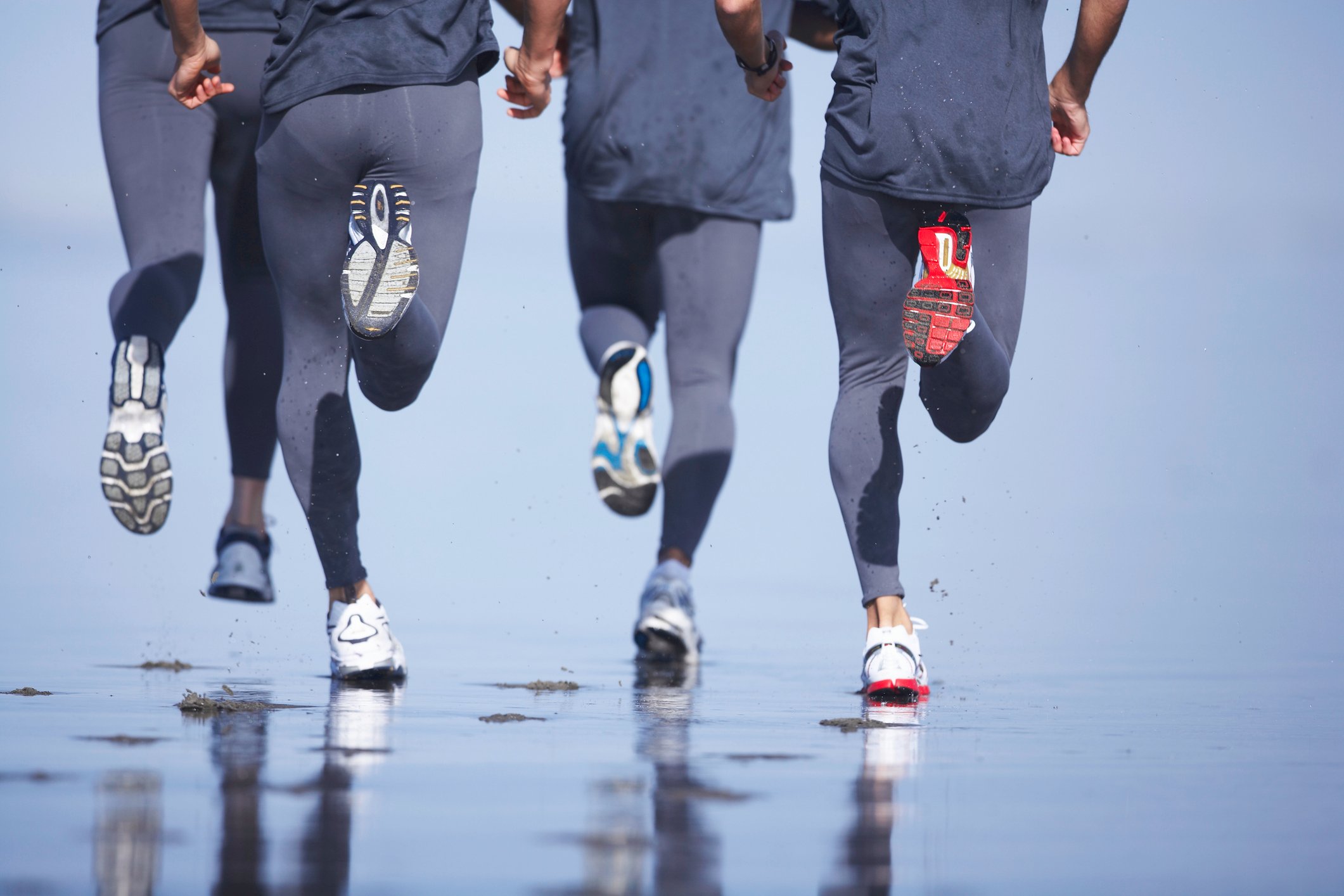 Joggers running on a beach.