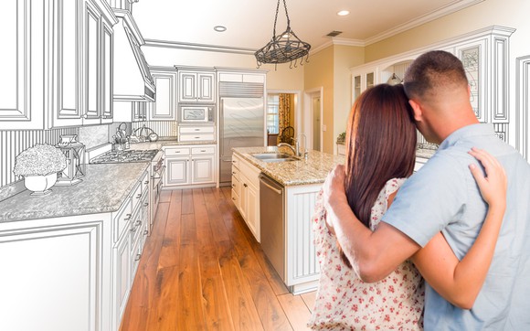 A couple looking at their kitchen and imagining what it might look like.