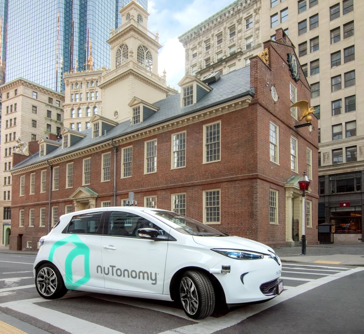 A white Renault Zoe with nuTonomy logos in front of the Old State House in downtown Boston, Massachusetts. 