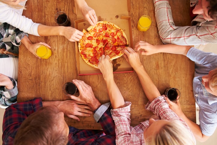 People sharing pizza at a table