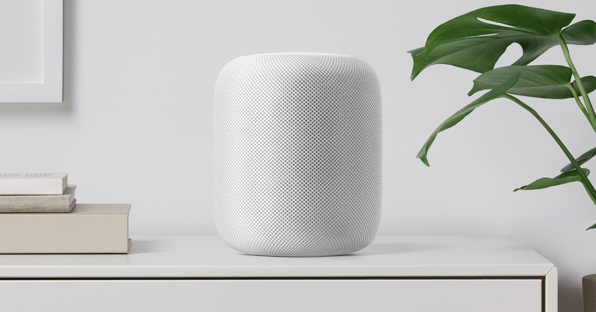 A white HomePod on a desk.