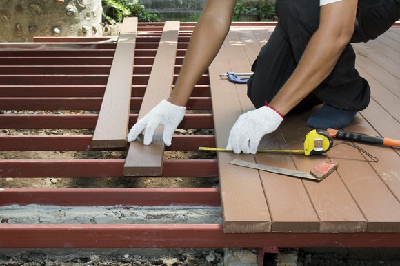 Worker installing wood decking.