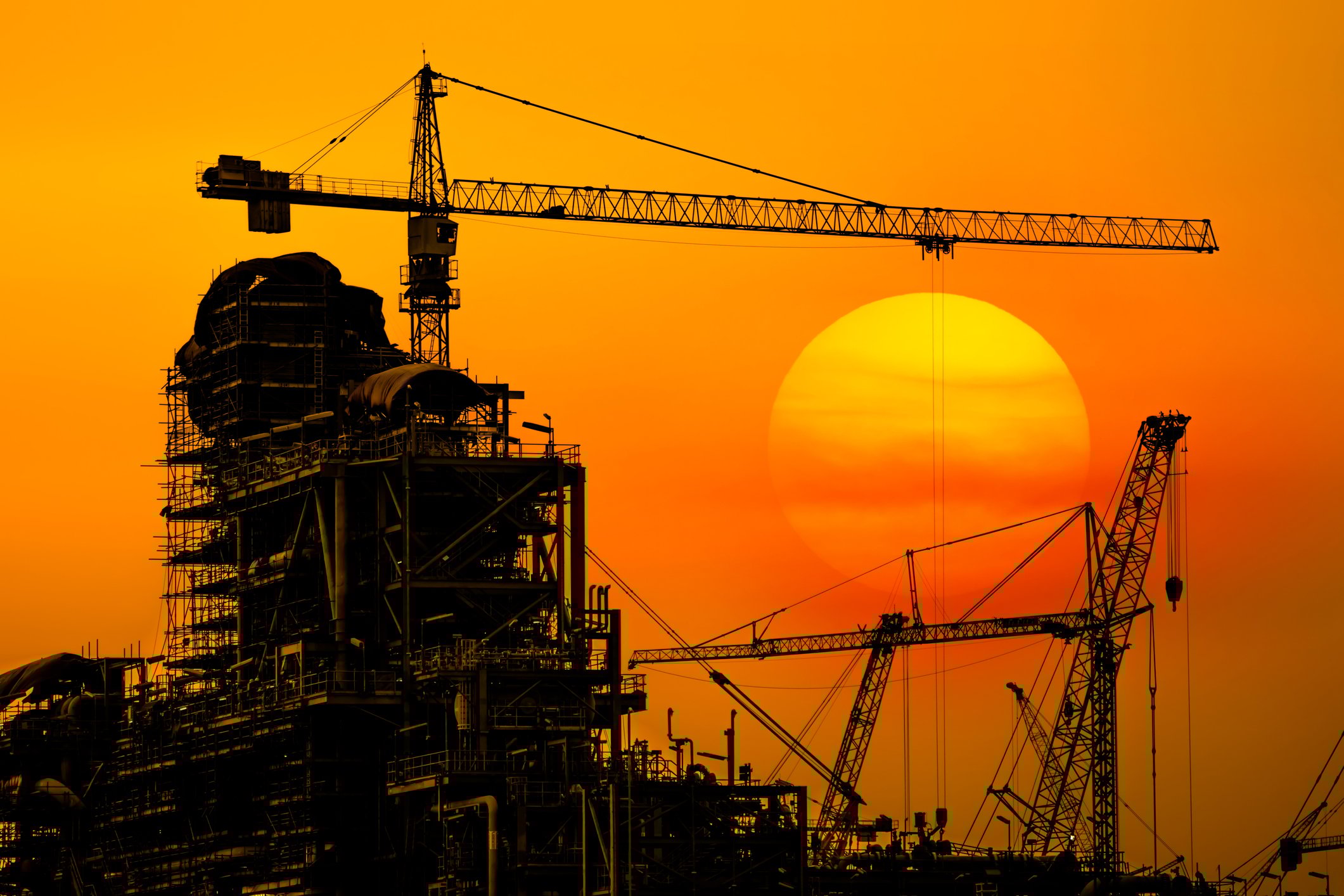 An industrial construction site at sunset.
