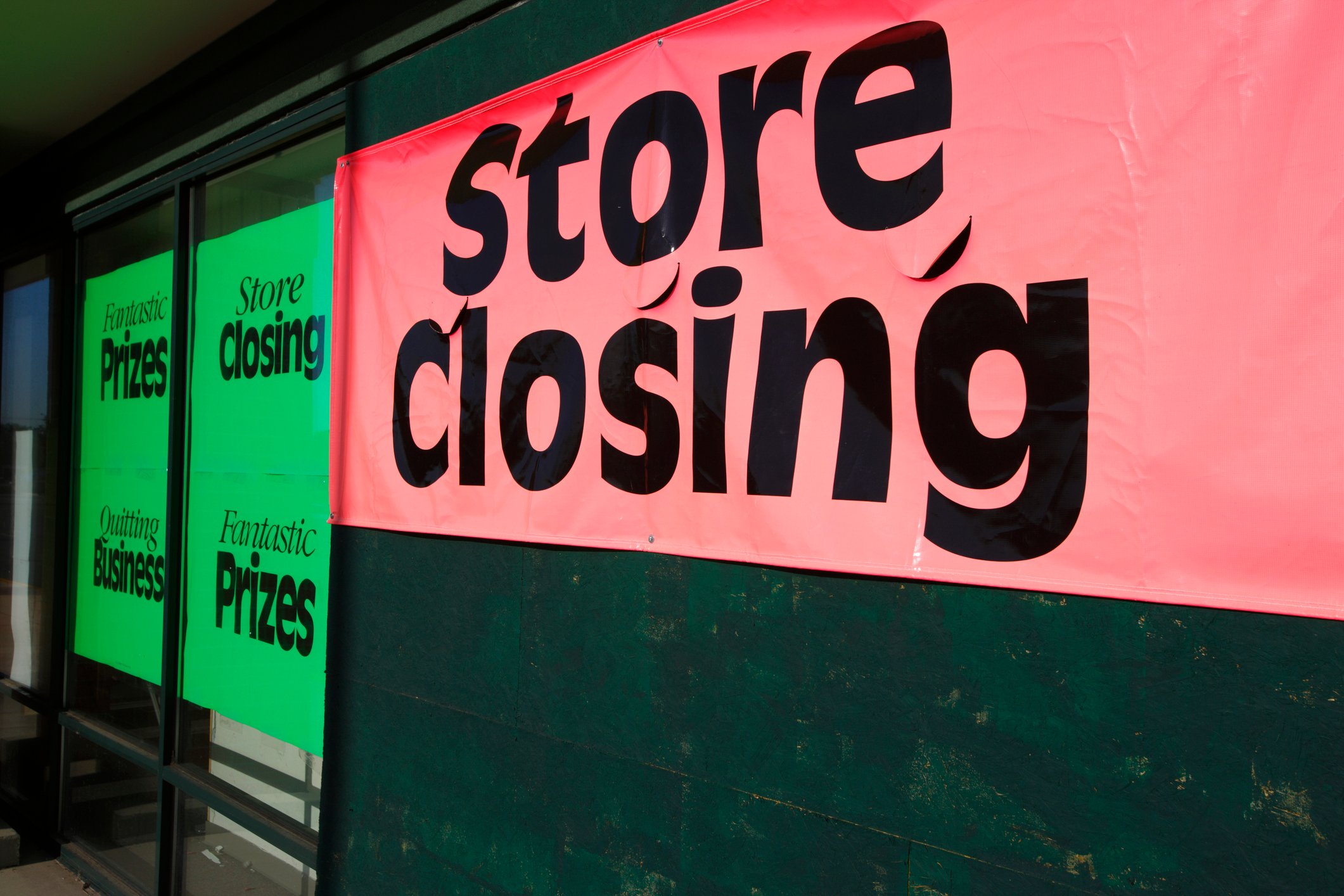 A "store closing" sign hangs from a storefront.