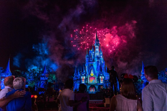 Onlookers enjoy the nightly Walt Disney World fireworks display over Cinderella Castle.