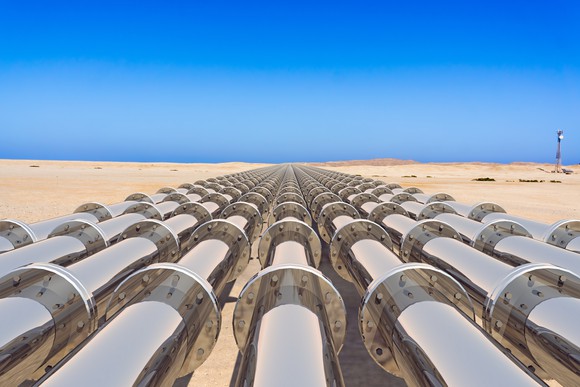 an energy pipeliine stretching across a sandy landscape toward the horizon