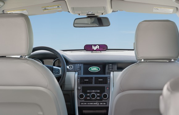 The interior of a Land Rover with a Lyft sign visible.