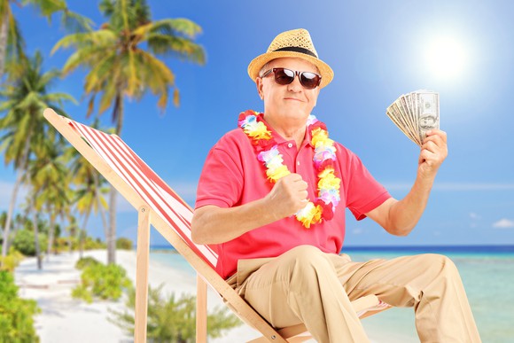 A retiree celebrating on the beach. 