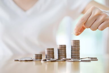 Woman stacking coins in rising piles