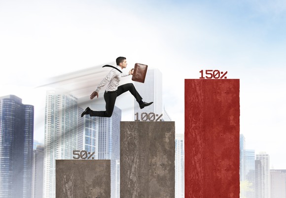 A man jumping up columns with different percentages on top