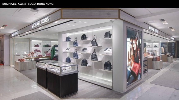 A Michael Kors storefront showing a display of handbags