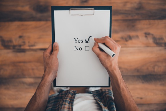 Man checking off "yes" on a yes or no checklist.