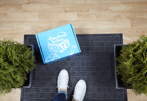 A Hasbro Game Crate on a front doorstep.