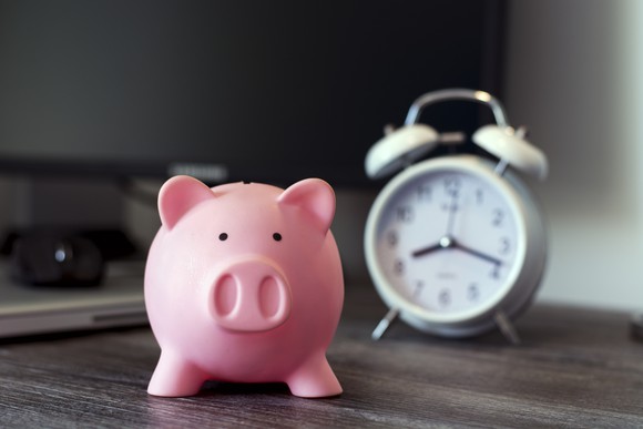 A piggy bank with a clock in the background