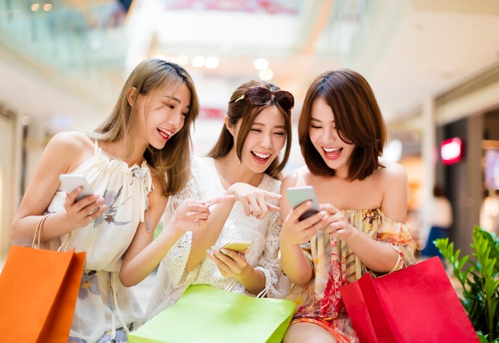 Chinese shoppers smiling together.