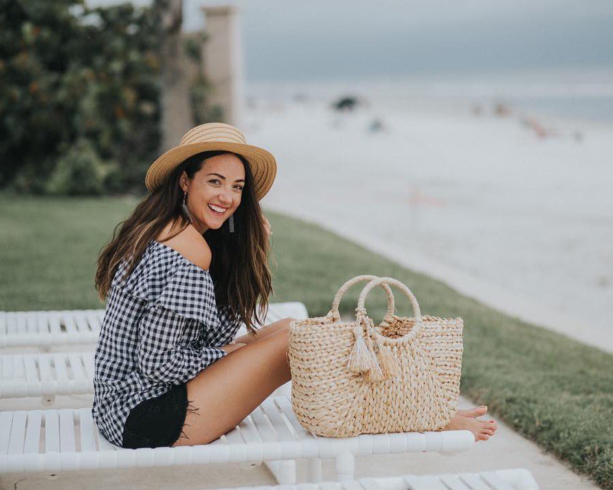 A woman poses at a beach setting