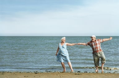 senior couple dancing on beach