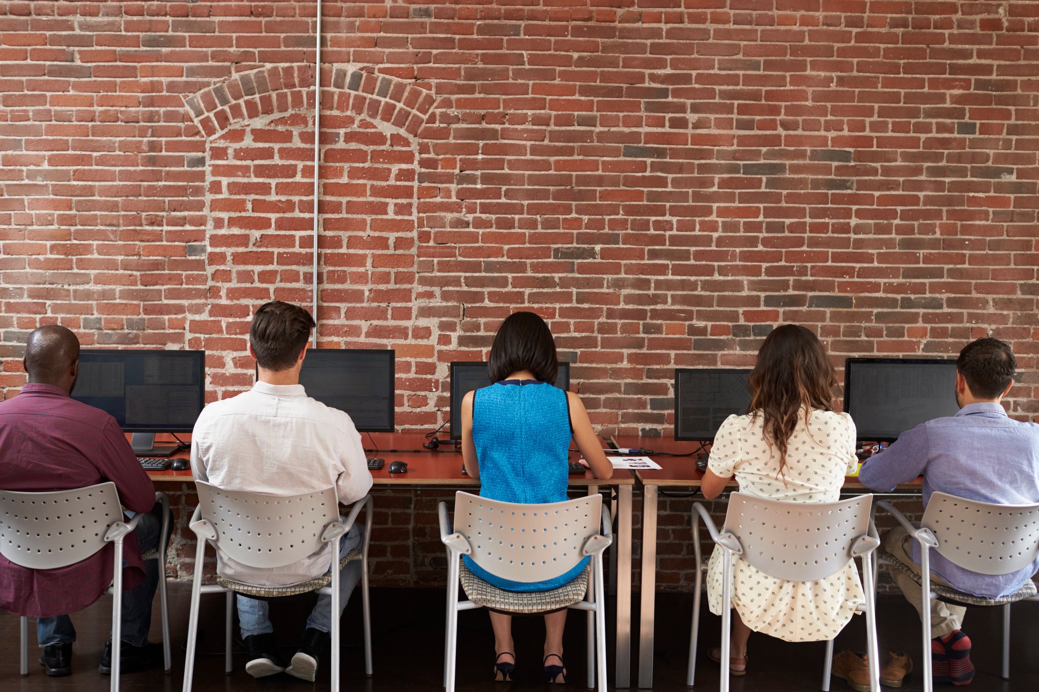 Office workers in a row, working on computers.