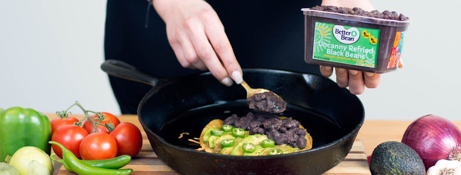 Someone cooking in a skillet with a product from The Better Bean Company