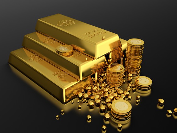 Gold bars are stacked next to gold coins and nuggets.