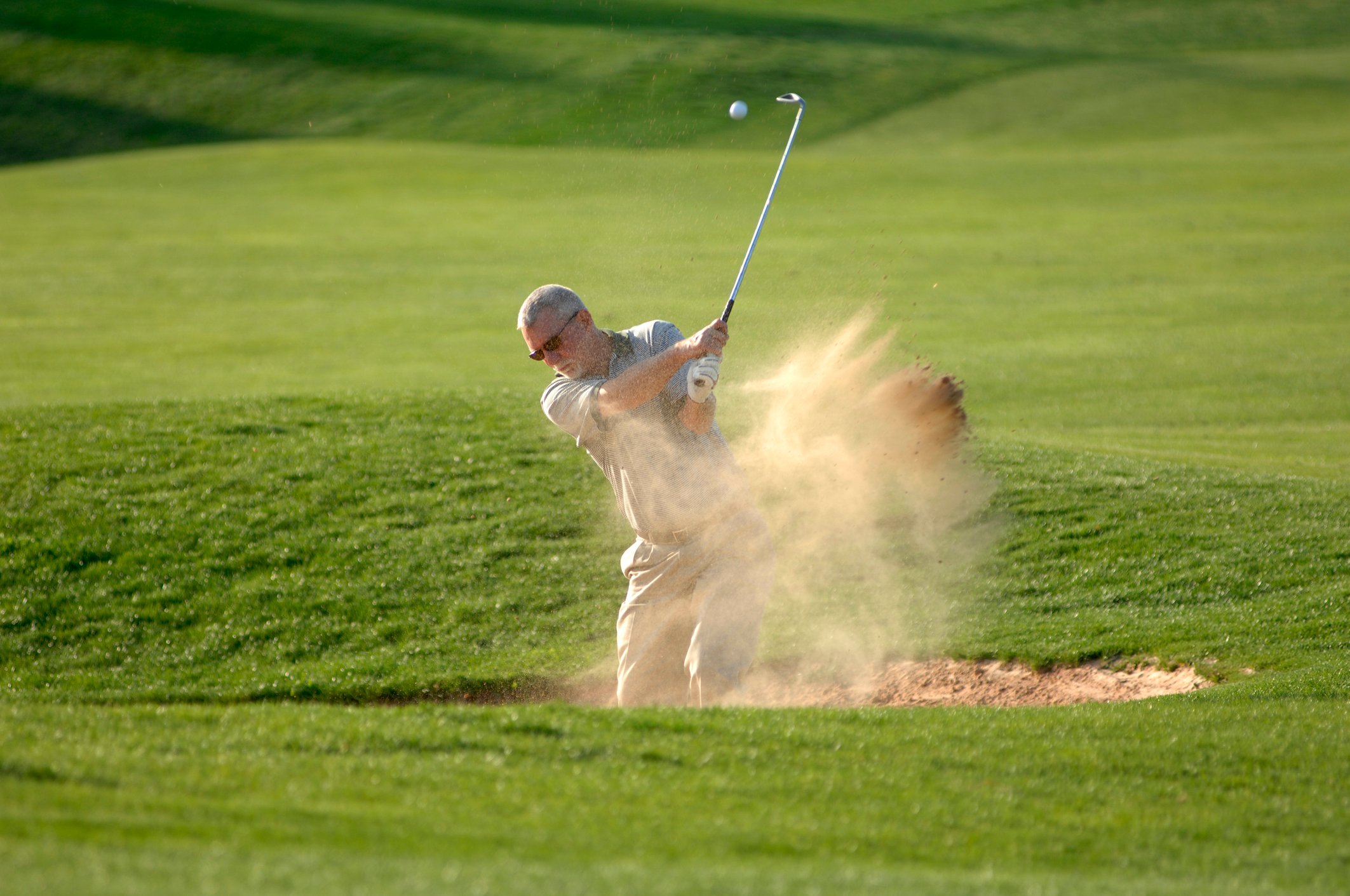 Man golfing in sand trap