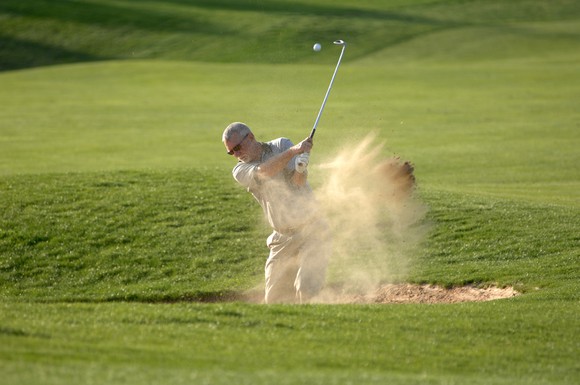 Man golfing in sand trap