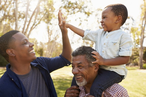 senior man with son and grandson in a park