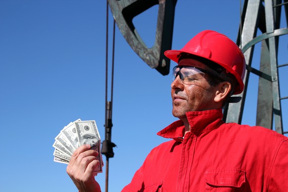 A rig worker holding cash.