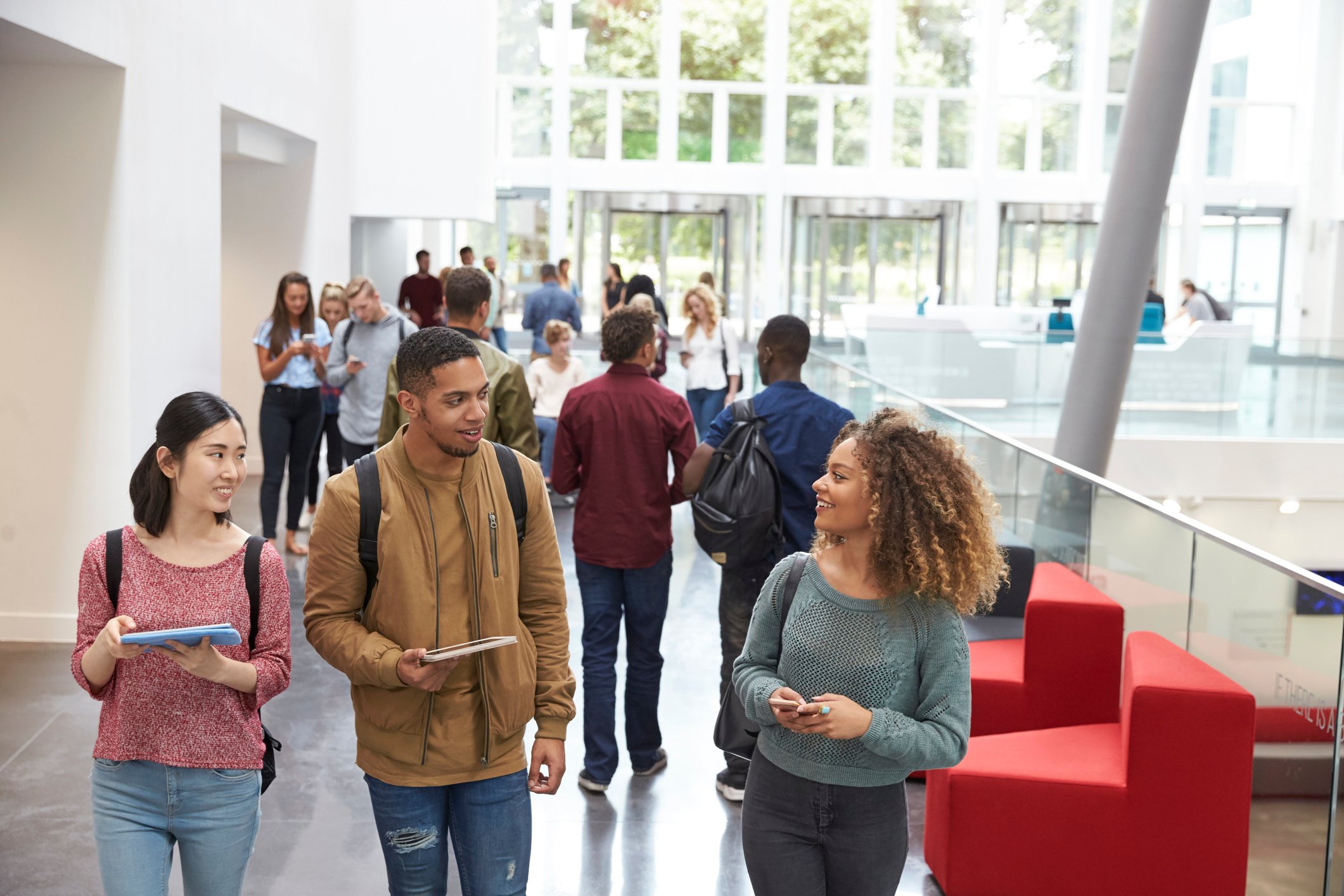 A group of young people walking along an indoor corridor.