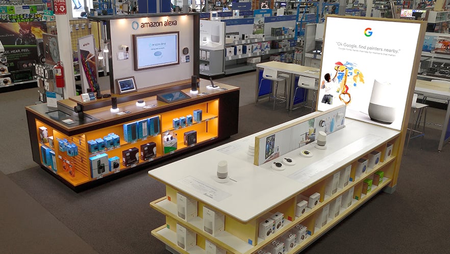 Side-by-side display cases of Amazon Echo and Google Home products.