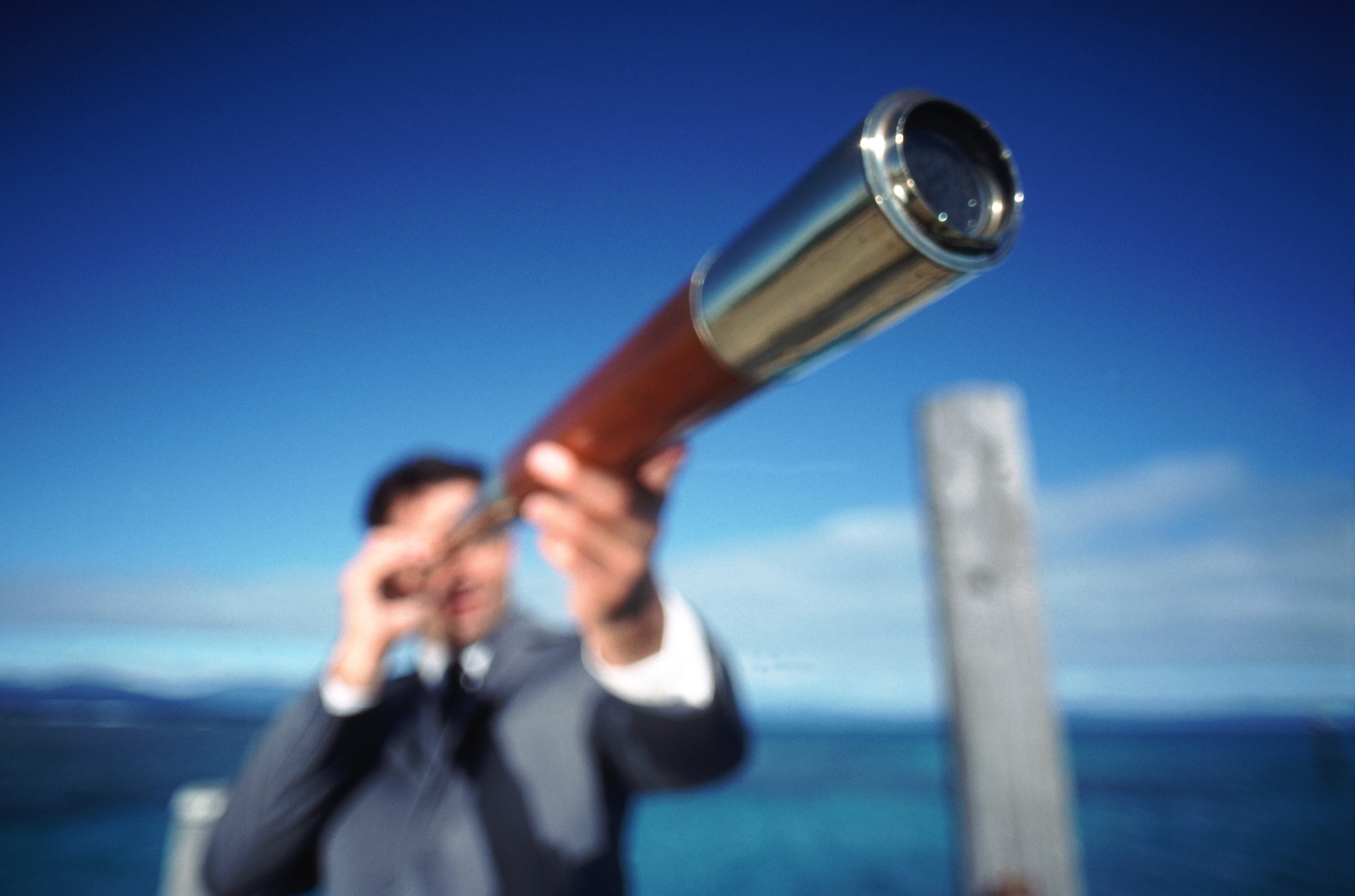 A man looking through a telescope.