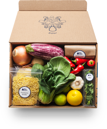 A Blue Apron delivery box containing noodles, vegetables, and fruit.