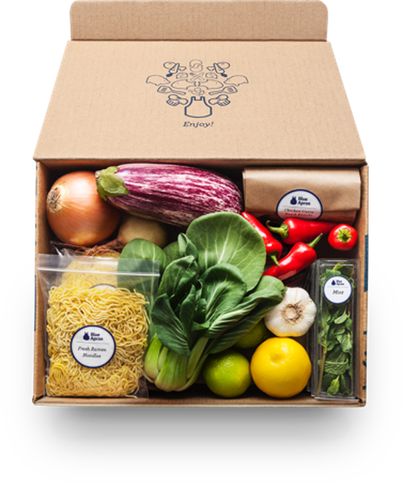 A Blue Apron delivery box containing noodles, vegetables, and fruit.