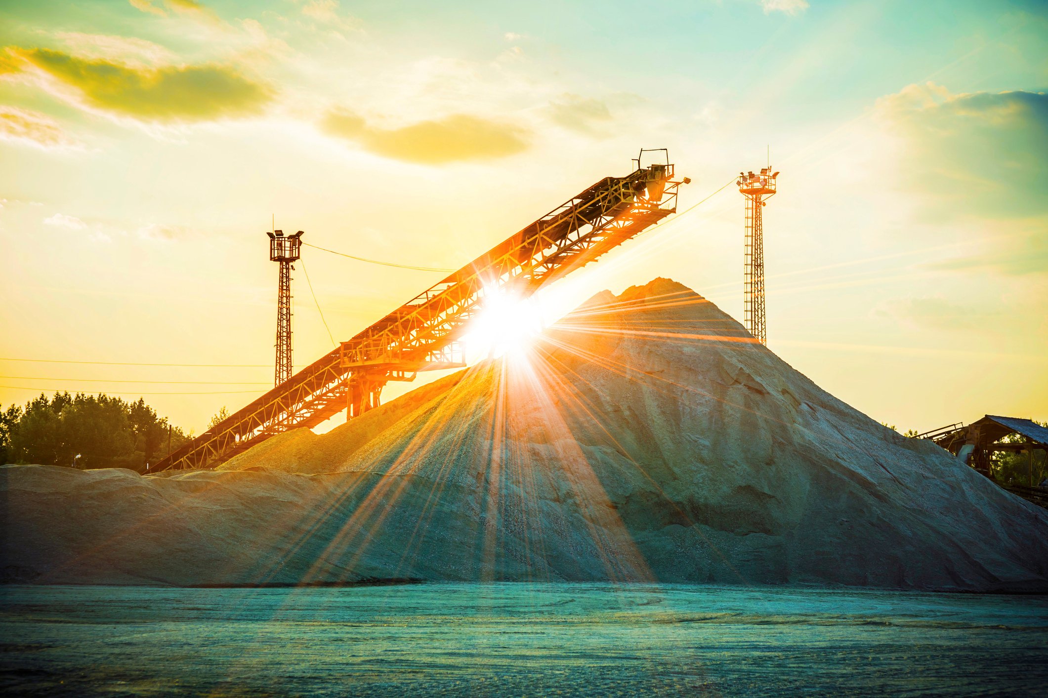The sun shining over a pile of sand.