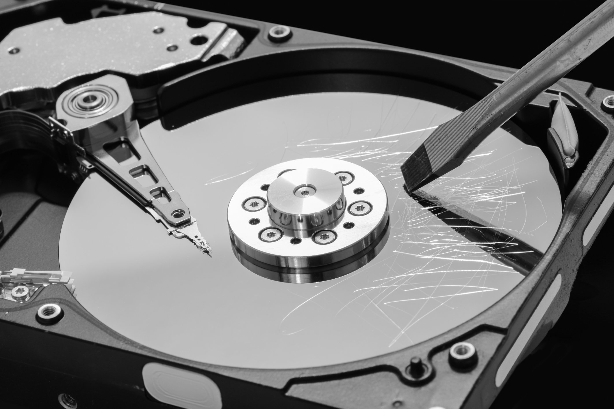 Traditional hard drive, opened up and vandalized with a screwdriver.