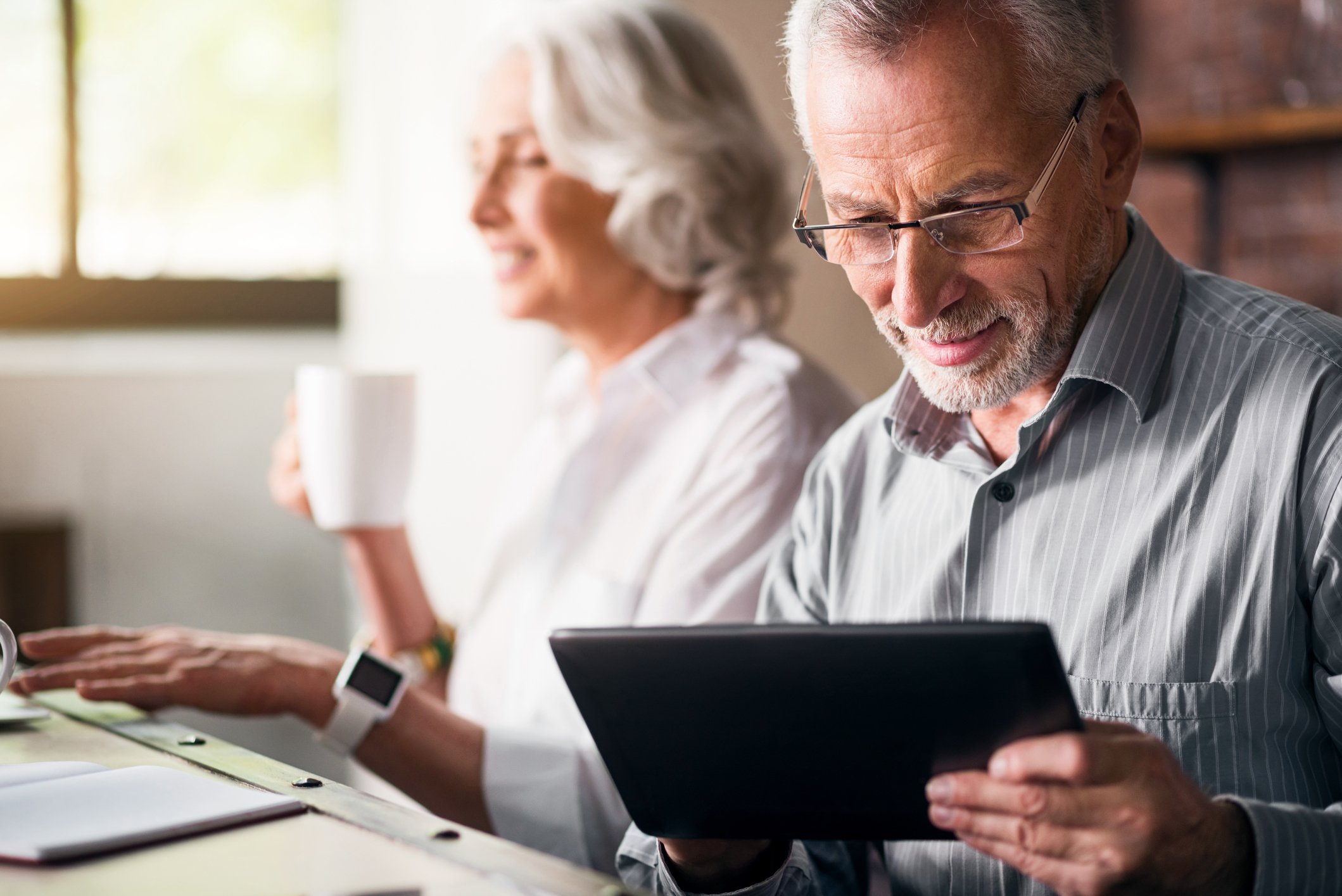 A baby boomer couple sits at a table considering their Social Security options.