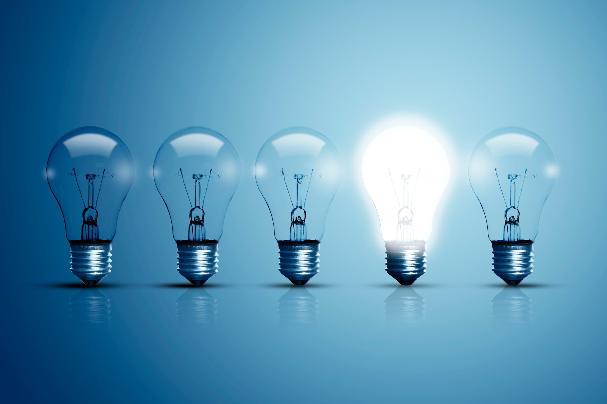 Five light bulbs with one lit up.