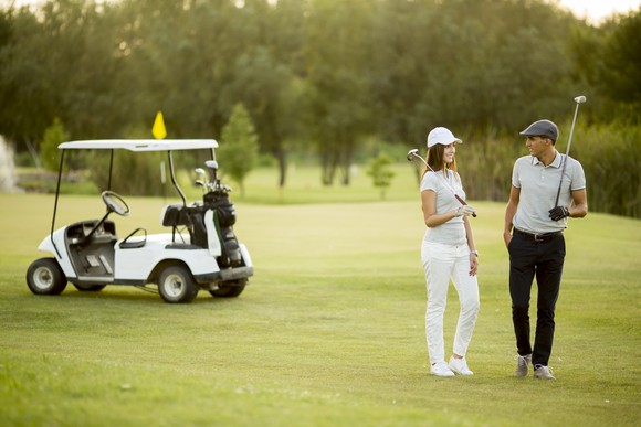 Woman and man playing golf.