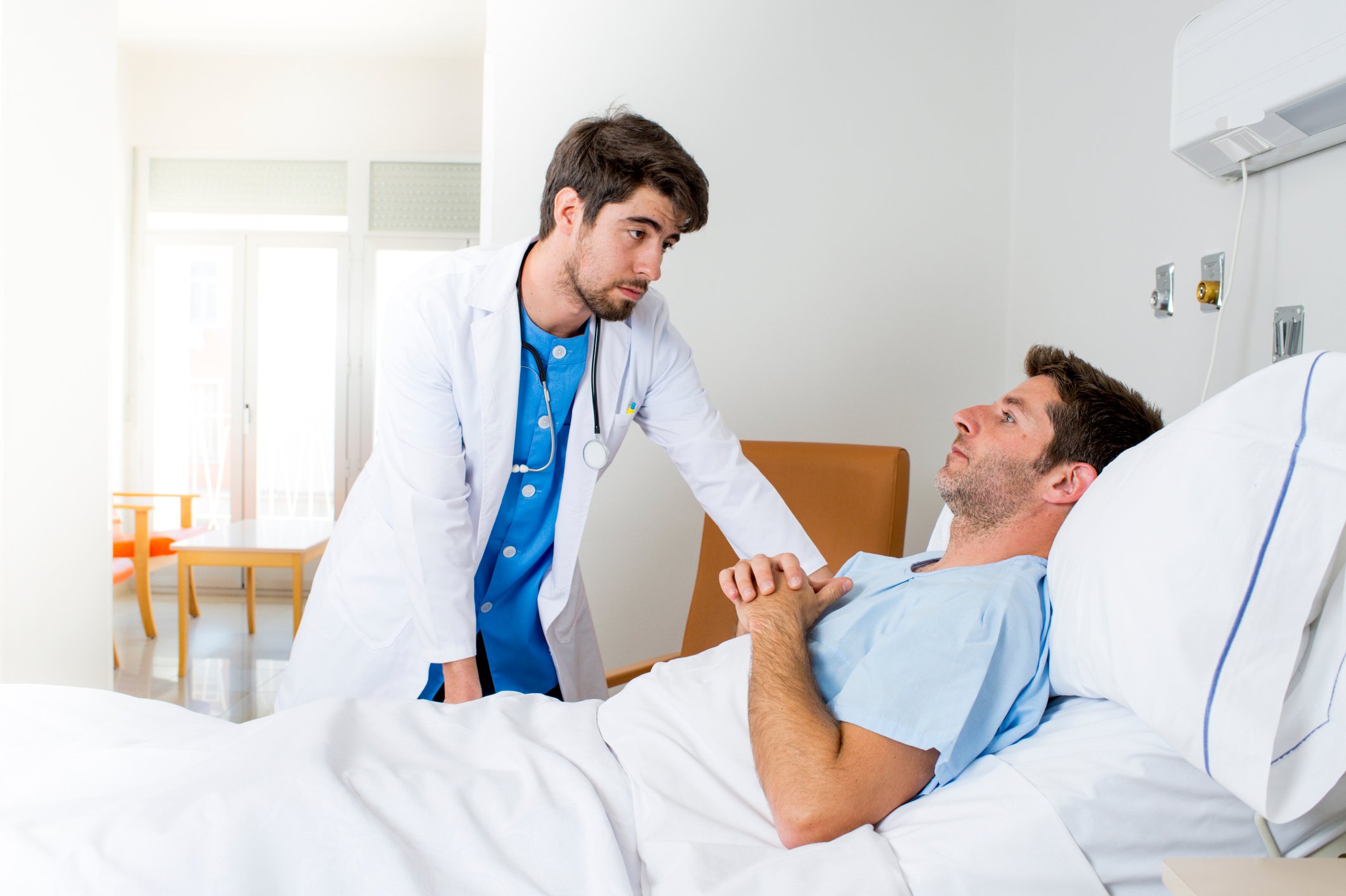A doctor visits a hospital patient.