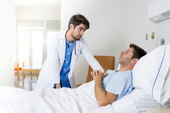 A doctor visits a hospital patient.
