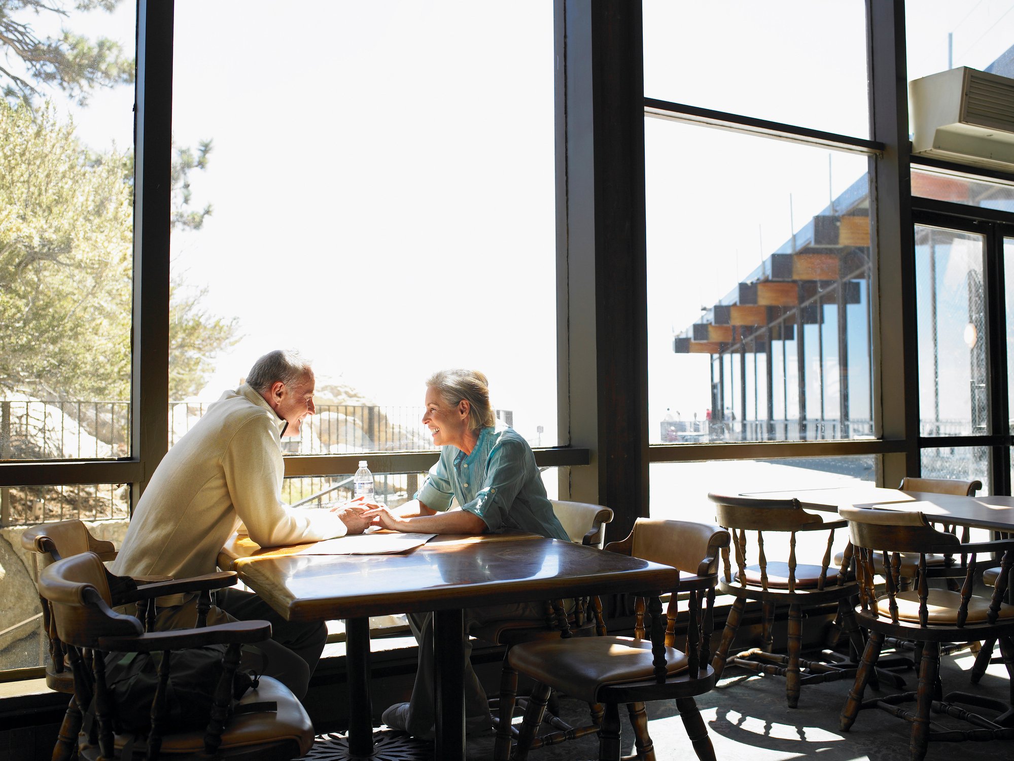 Retired couple holding hands in restaurant