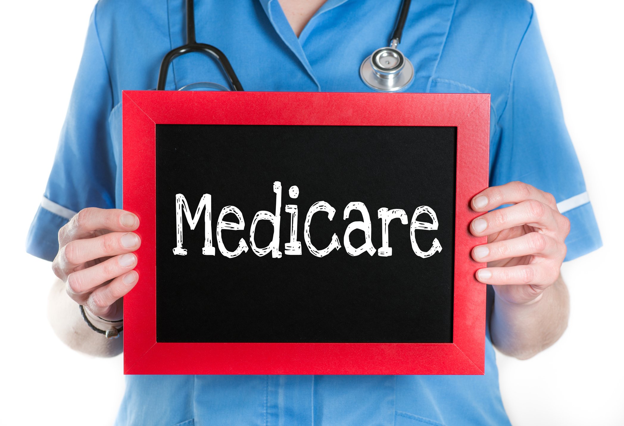 Nurse holding chalkboard with "Medicare" on it.